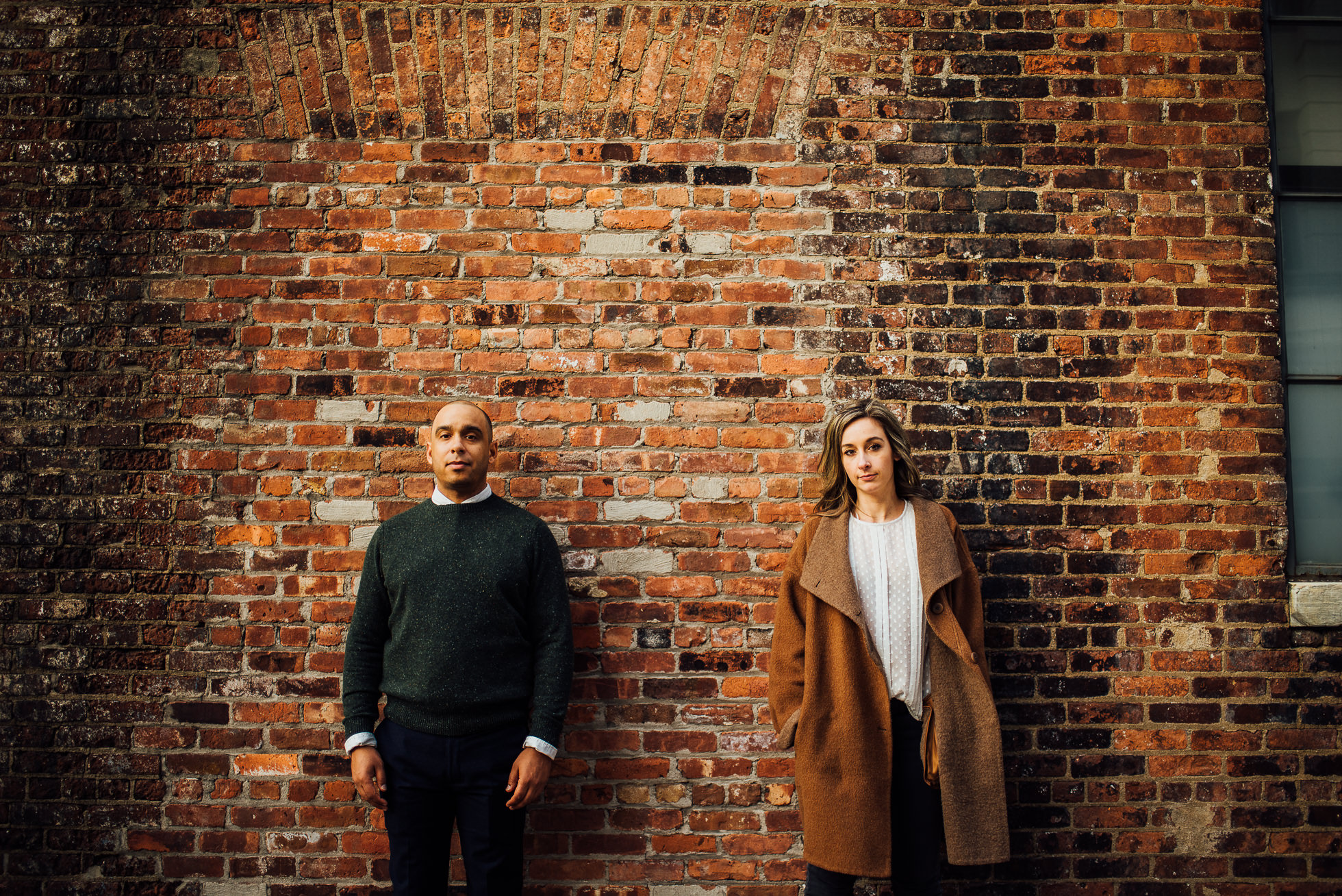 couple in front of brick wall