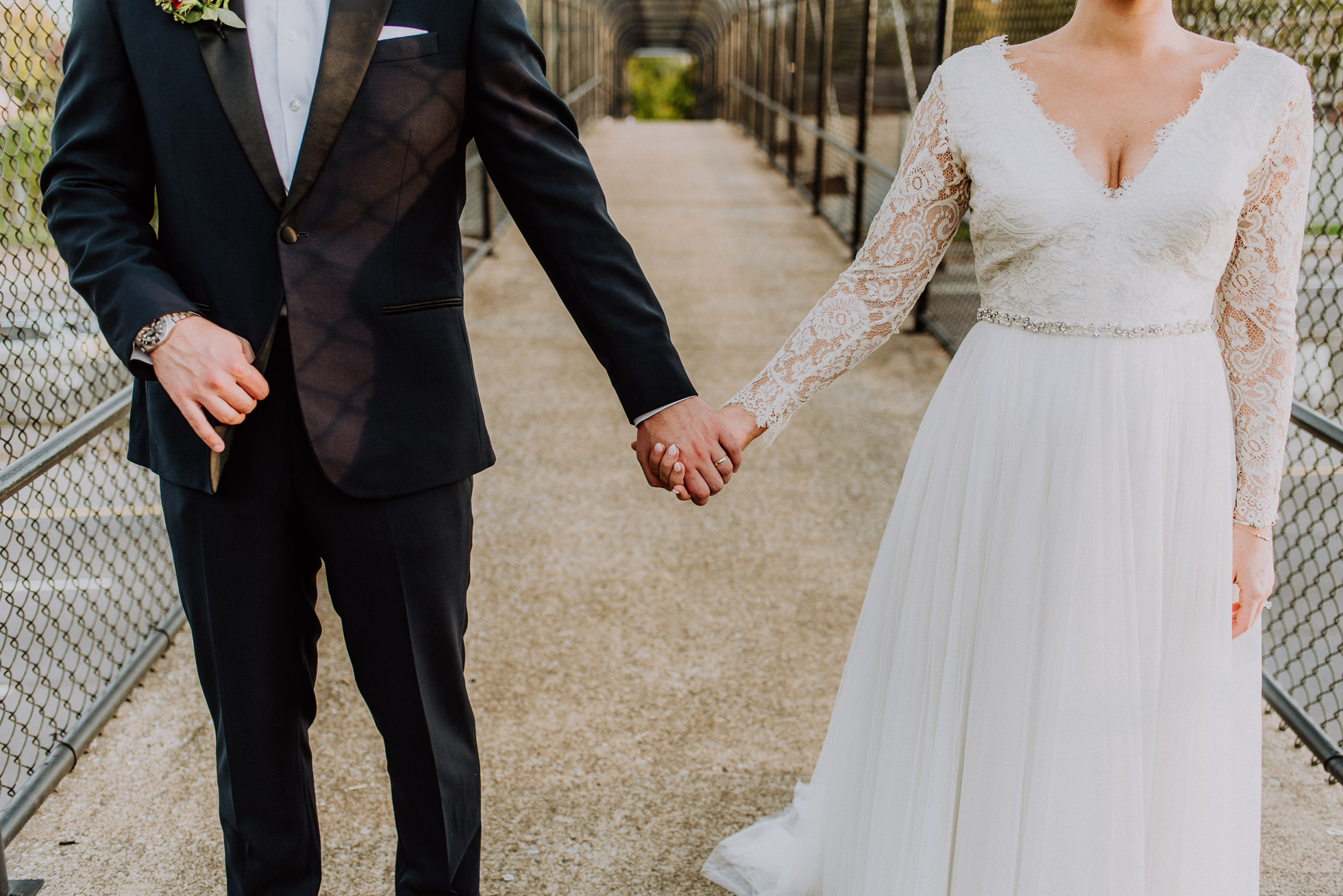 bride and groom holding hands on overpass in nashville tennessee