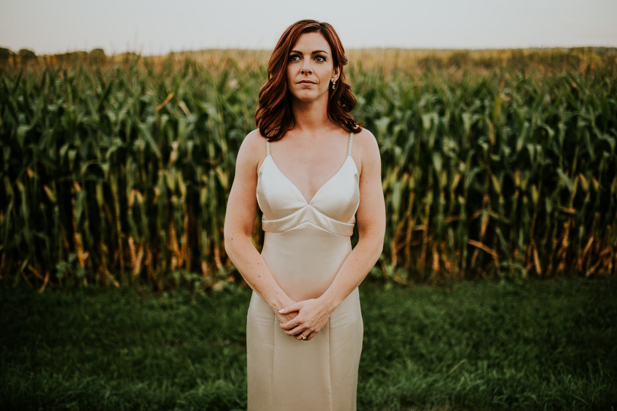 bride portrait near corn field at olde tater barn wedding in central bridge, ny photographed by traverse the tides