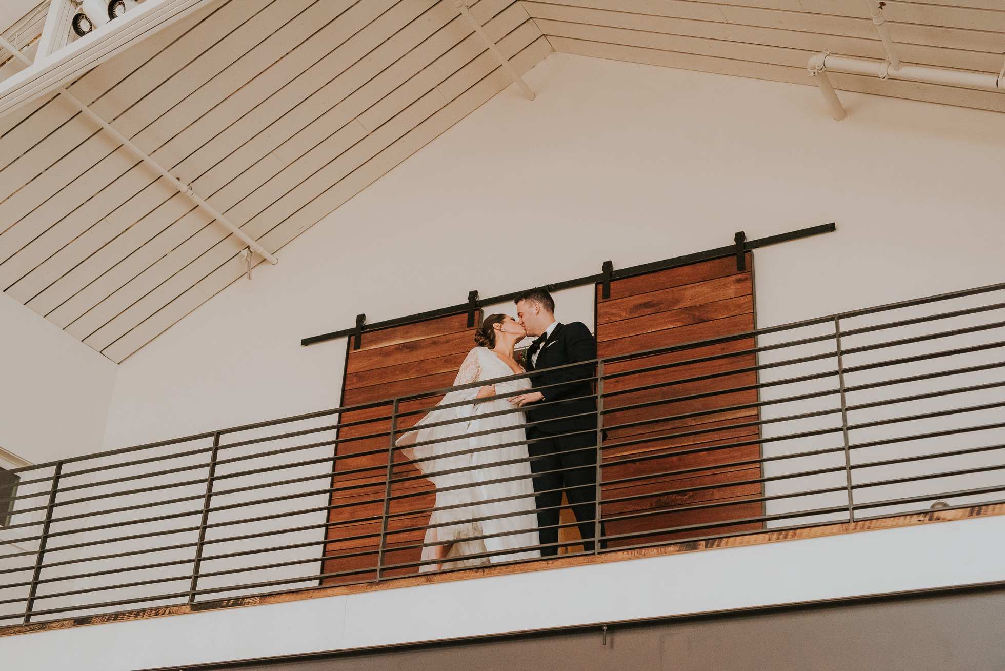 bride and groom kiss on balcony at the cordelle nashville