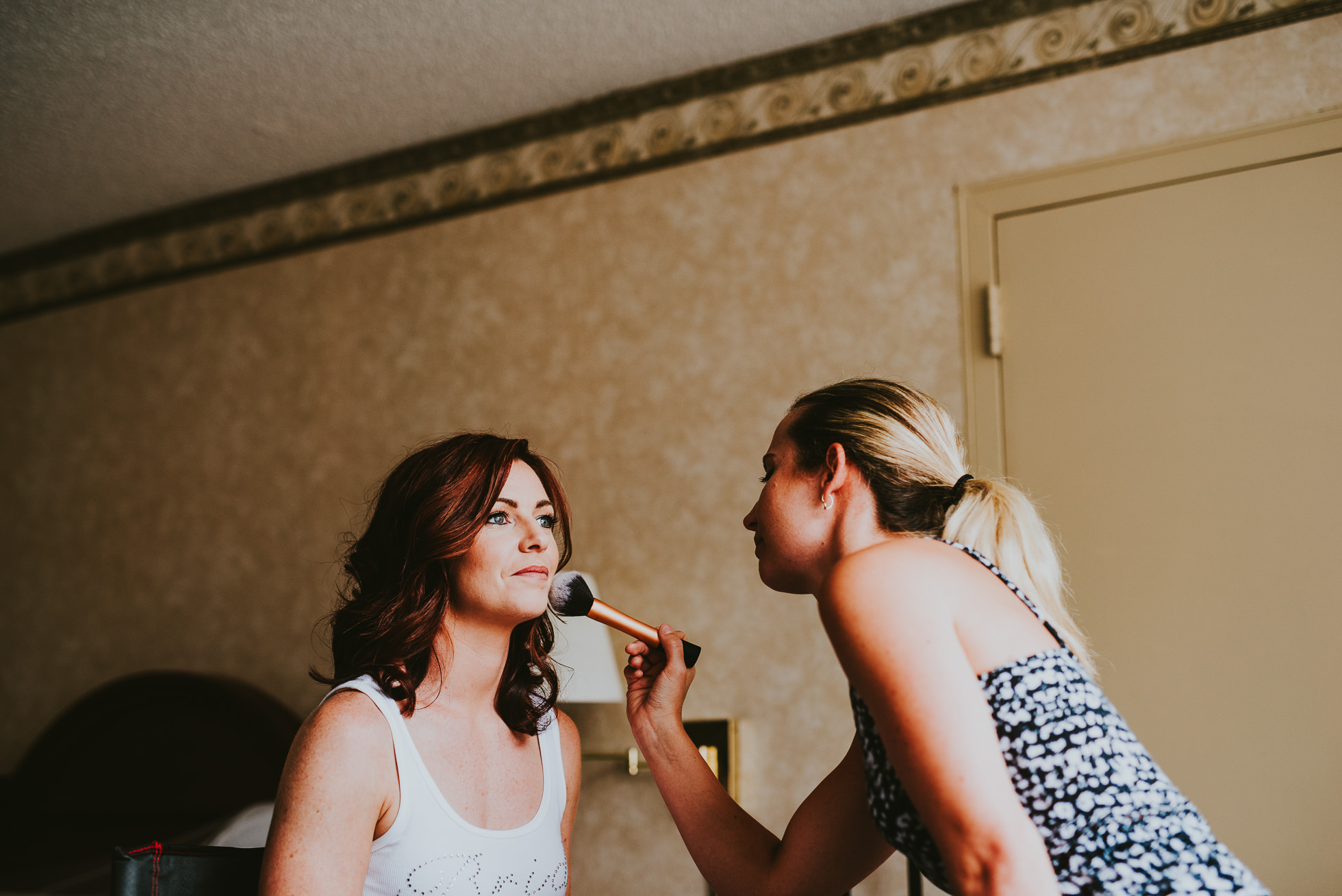 bride getting makeup at olde tater barn wedding in central bridge, ny photographed by traverse the tides
