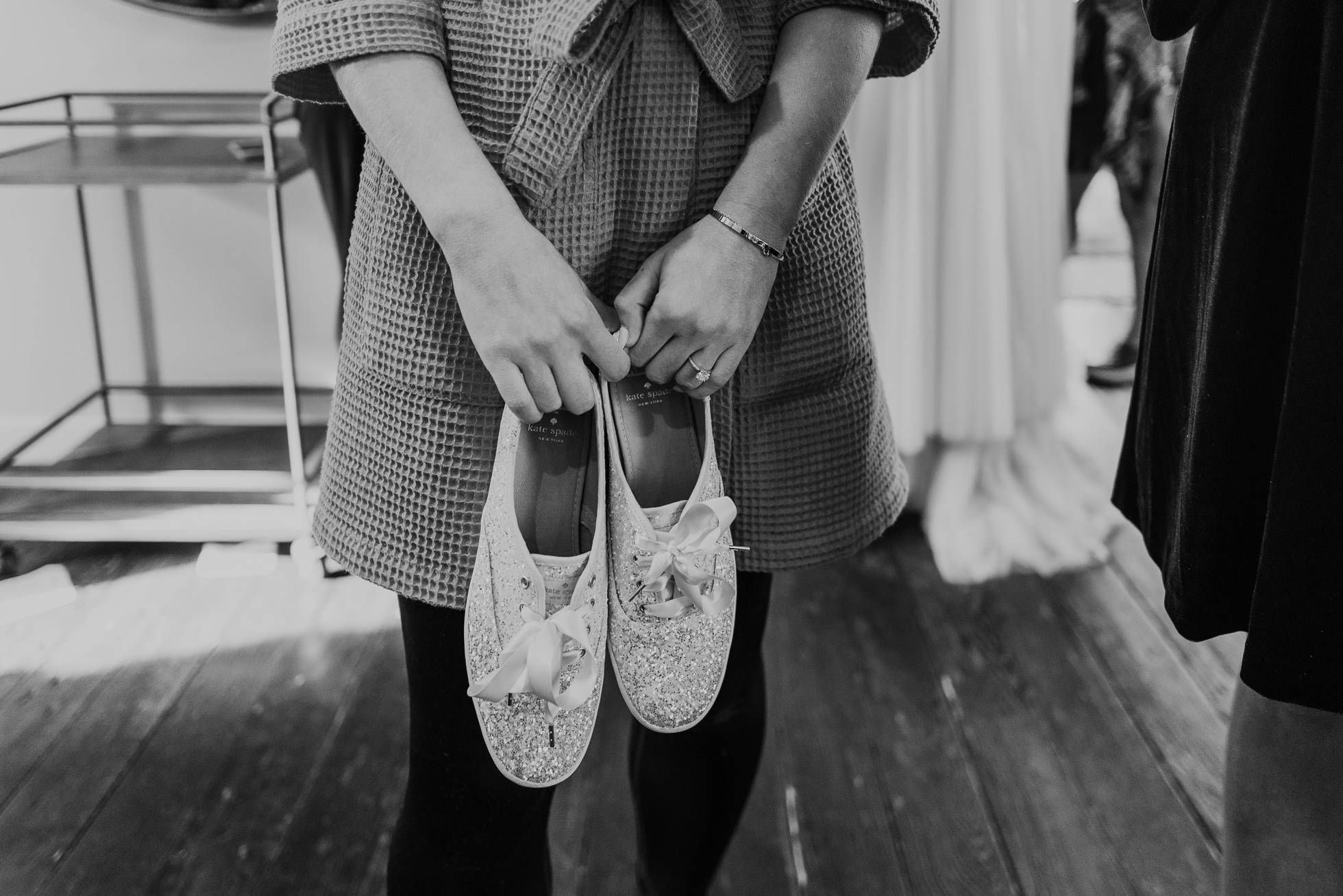 bride holding keds shoes the cordelle