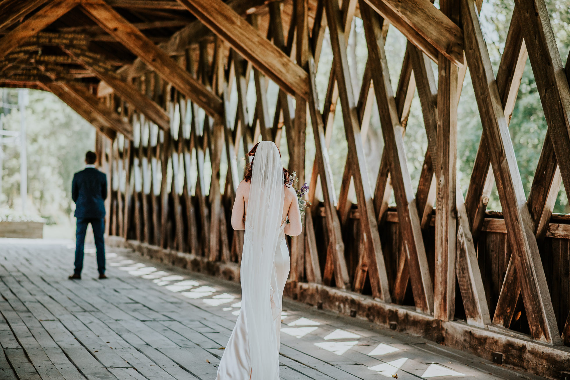 bride walking to first look at olde tater barn wedding in central bridge, ny photographed by traverse the tides