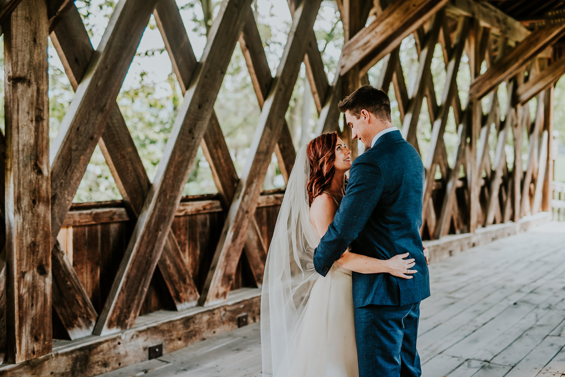 bride and groom portrait on bridge at olde tater barn wedding in central bridge, ny photographed by traverse the tides