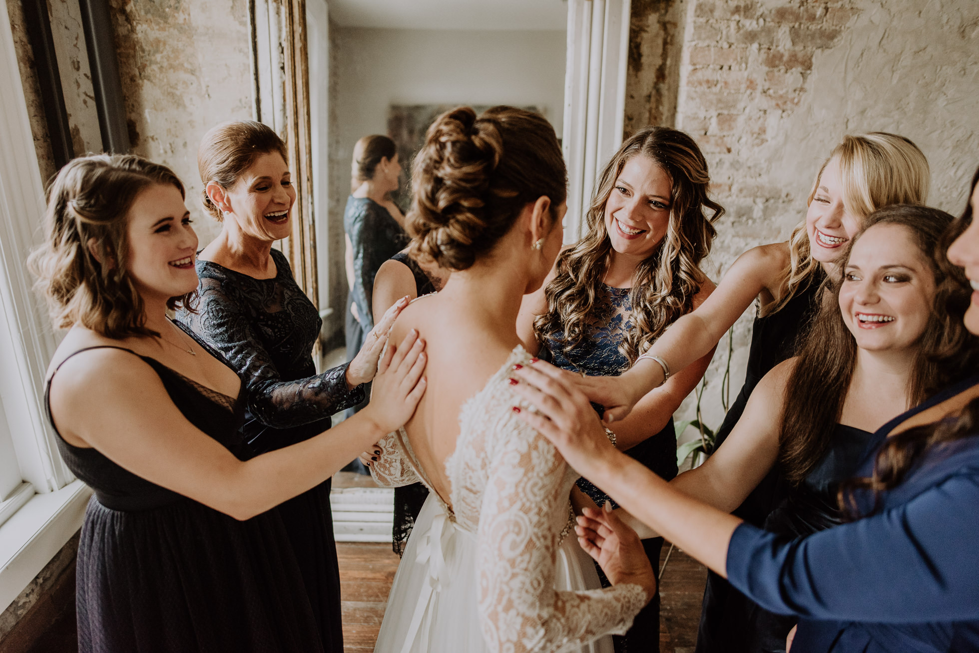 friends placing hands on the bride at the cordelle