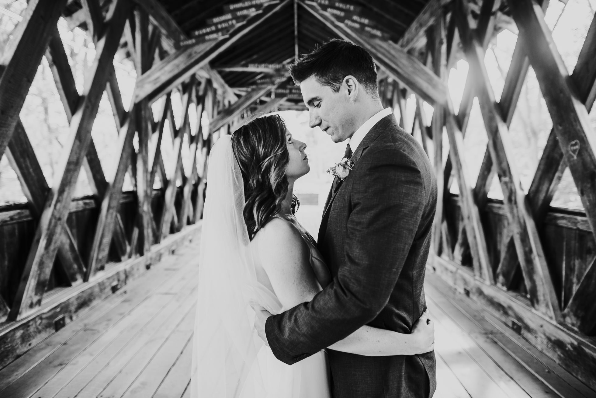 bride and groom portrait on bridge at olde tater barn wedding in central bridge, ny photographed by traverse the tides
