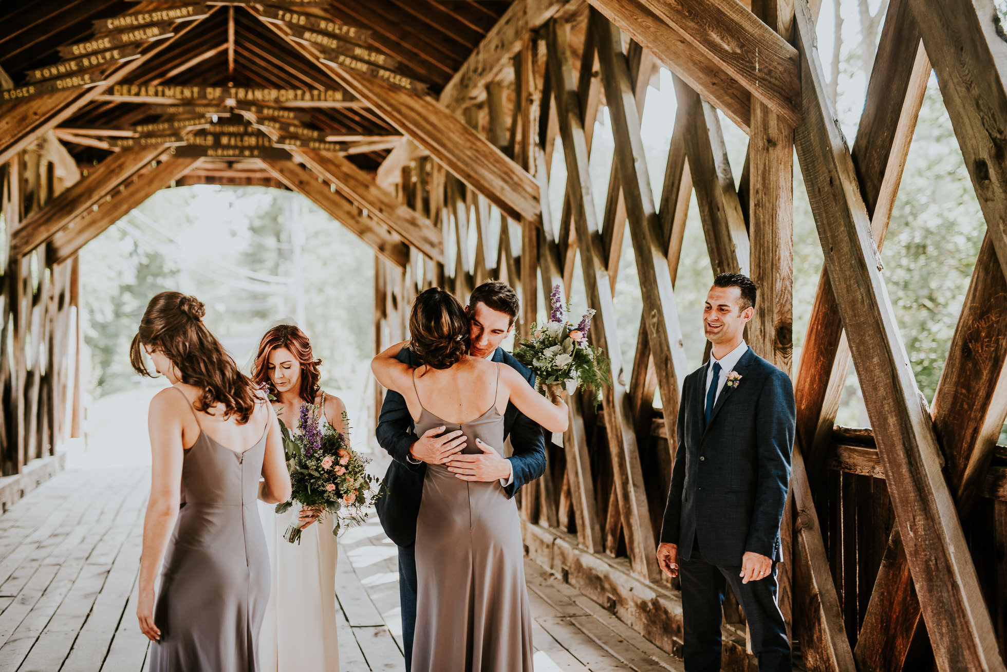 bridal party on bridge at olde tater barn wedding in central bridge, ny photographed by traverse the tides