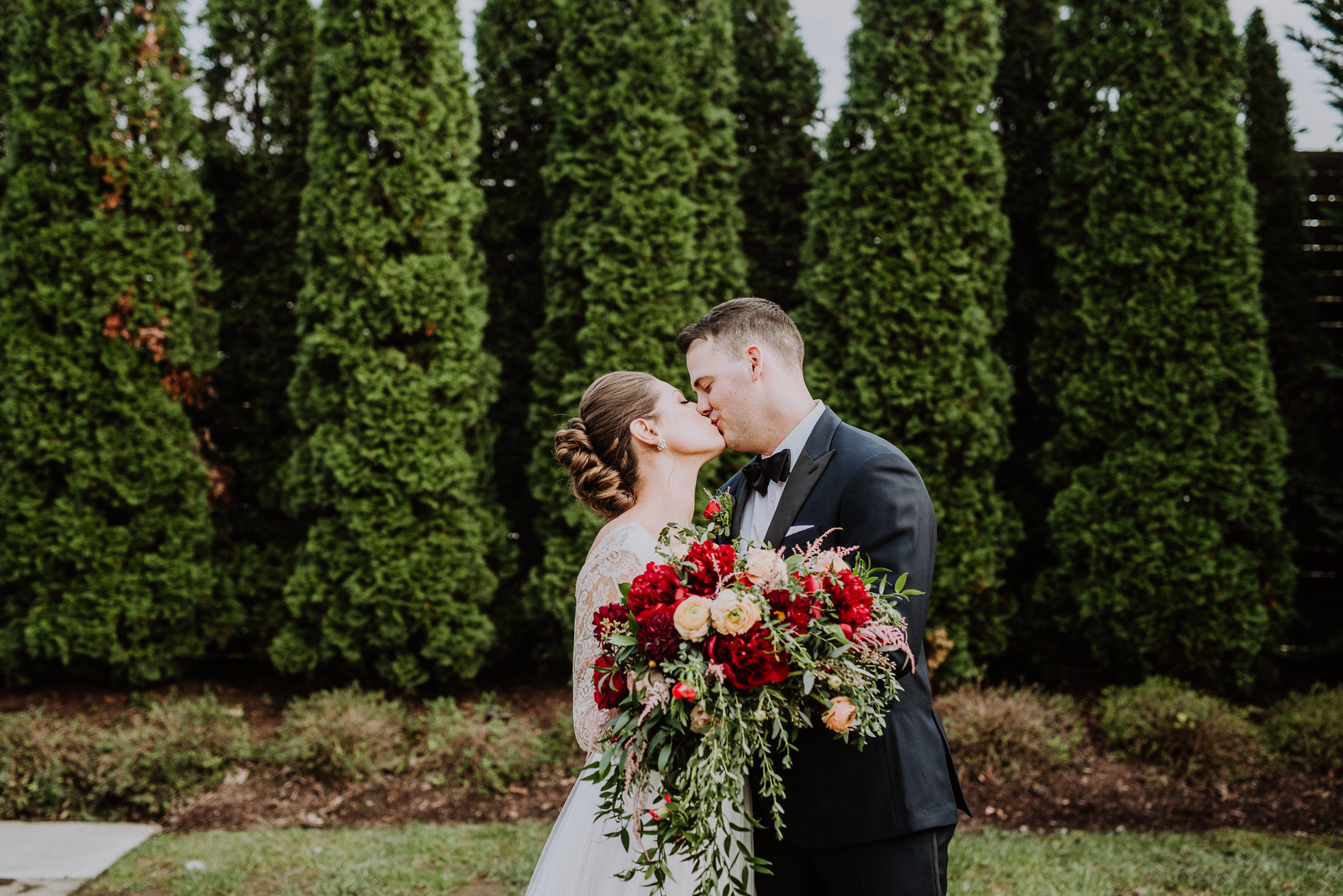 bride and groom kissing and holding bouquet the cordelle nashville