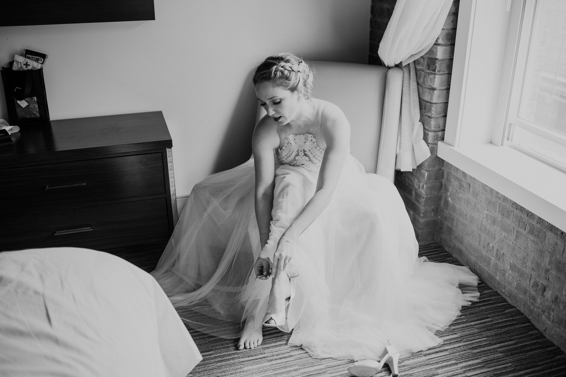 bride putting on shoes photographed by Traverse The Tides