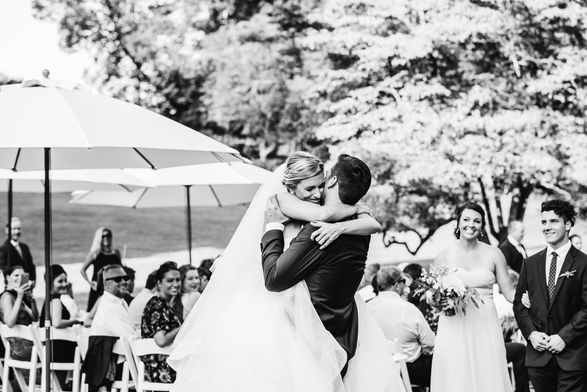 bride and groom hug at wedding ceremony at lyndhurst castle photographed by traverse the tides