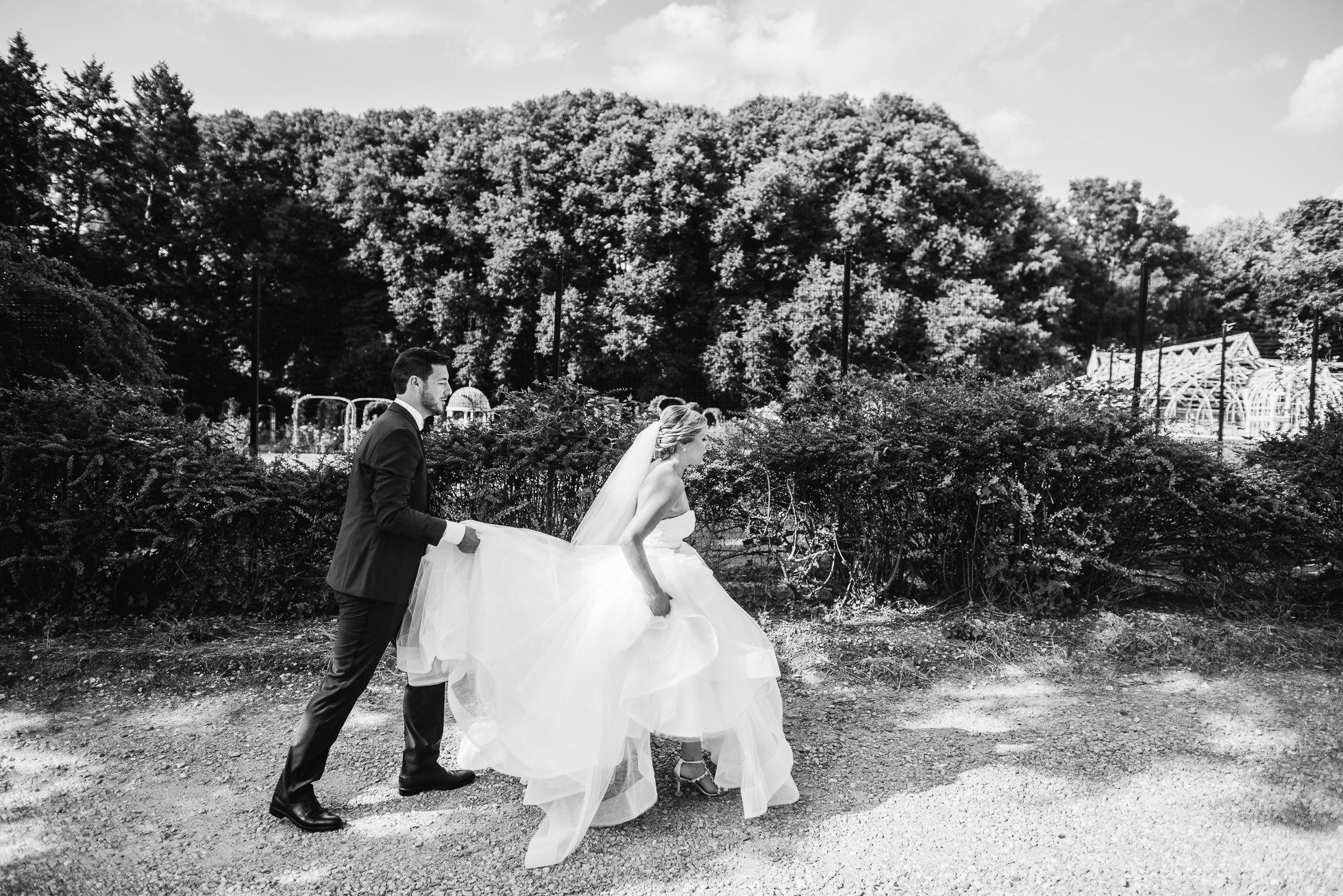 bride and groom walking at lyndhurst castle rose garden photographed by traverse the tides