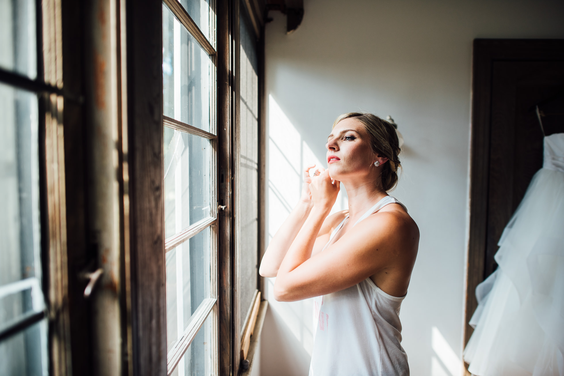 bride putting earrings on at lyndhurst castle photographed by traverse the tides