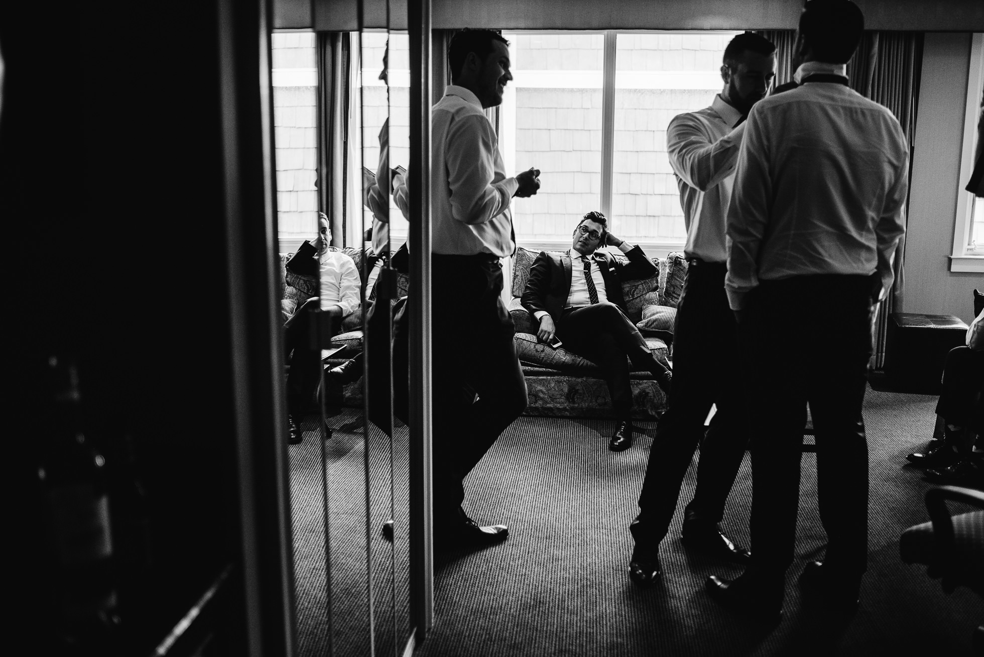 groom putting on tie at lyndhurst castle wedding photographed by traverse the tides-2