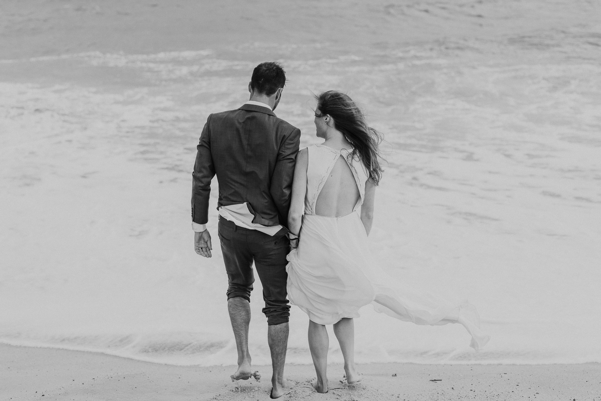 bride and groom going into the water at beach Montauk wedding photographed by Traverse the Tides