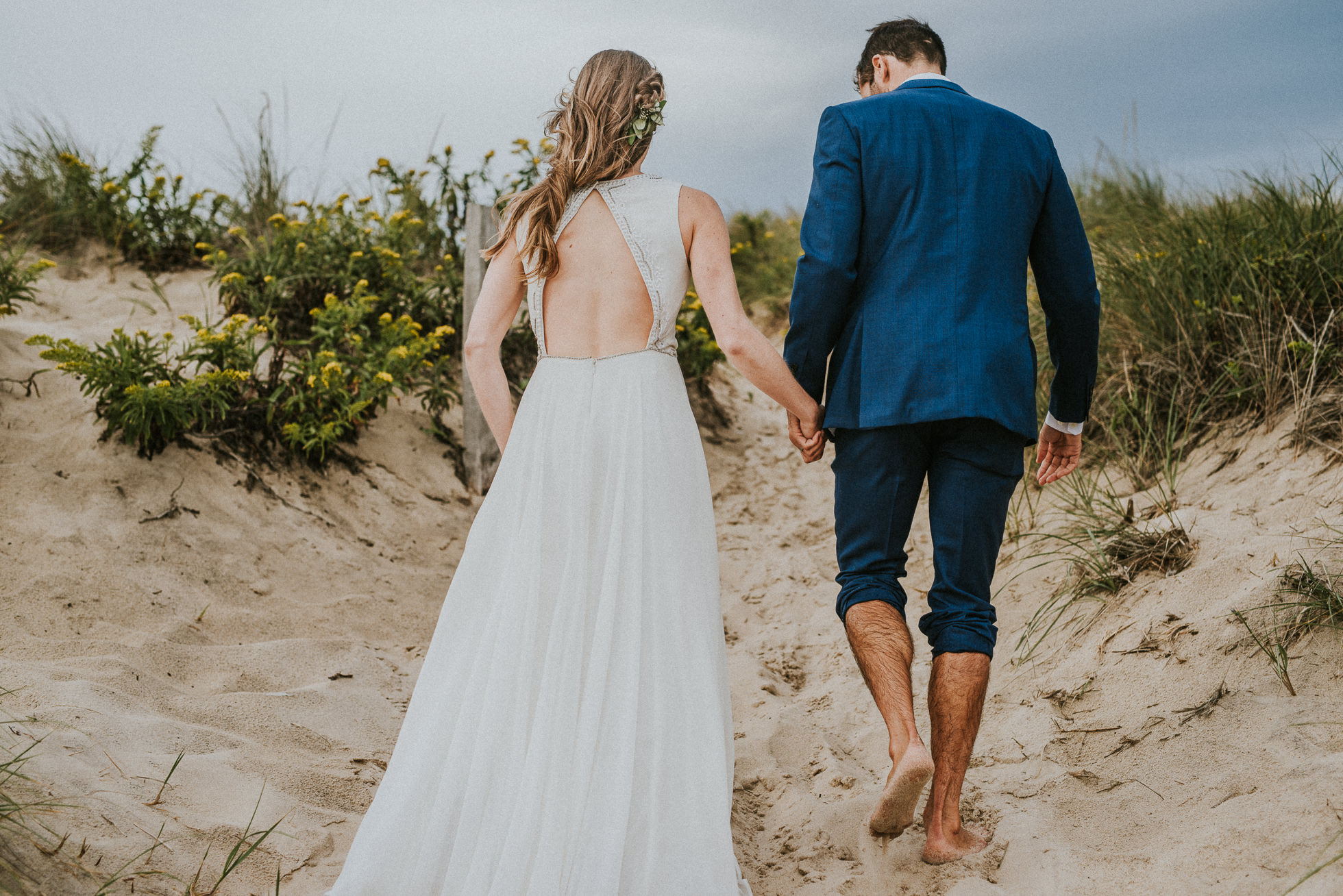 bride and groom walking hand in hand Montauk wedding photographed by Traverse the Tides