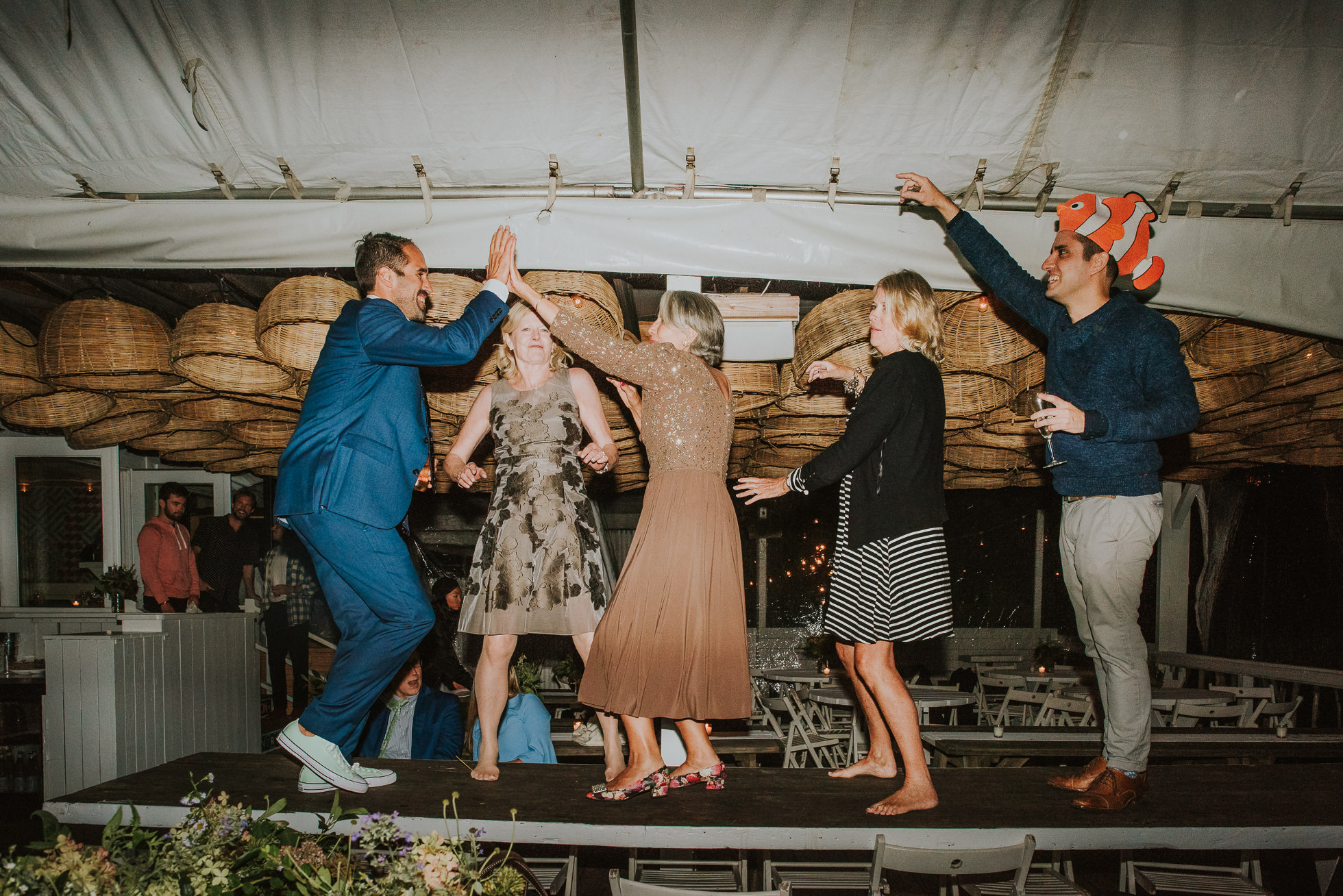 guests dancing on table at reception Montauk wedding photographed by Traverse the Tides