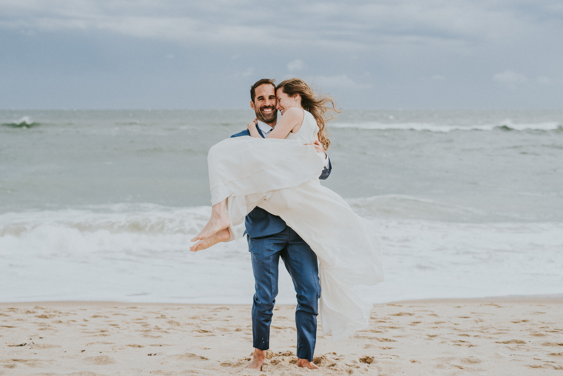 groom carrying bride at beach Montauk wedding photographed by Traverse the Tides