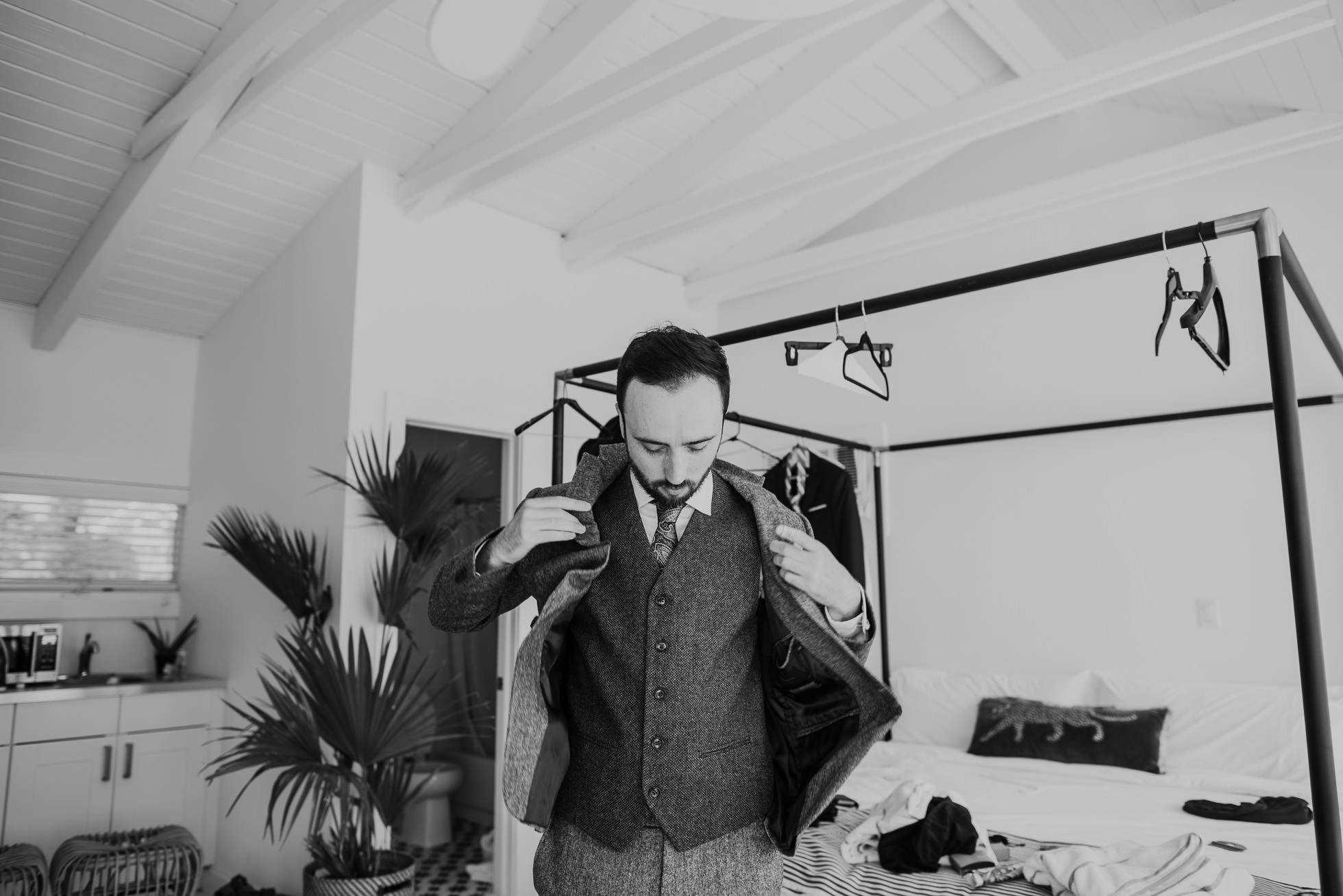 groom putting on wool suit jacket