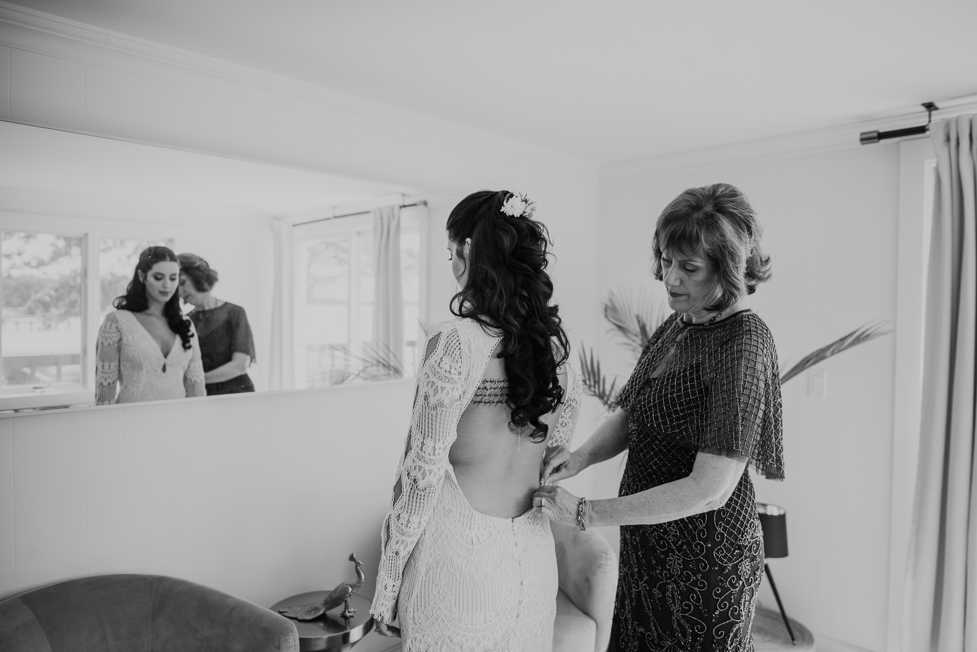 mom helping bride into dress